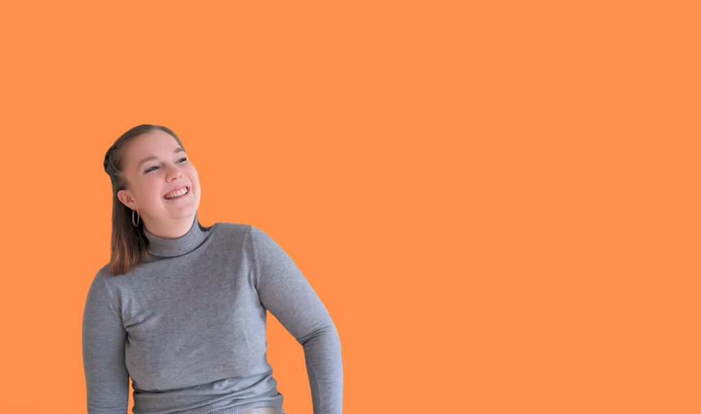 Frau mit grauem Pulli, schaut nach rechts, lächelt und hat dunkelblonde Haare vor orangenem Hintergrund