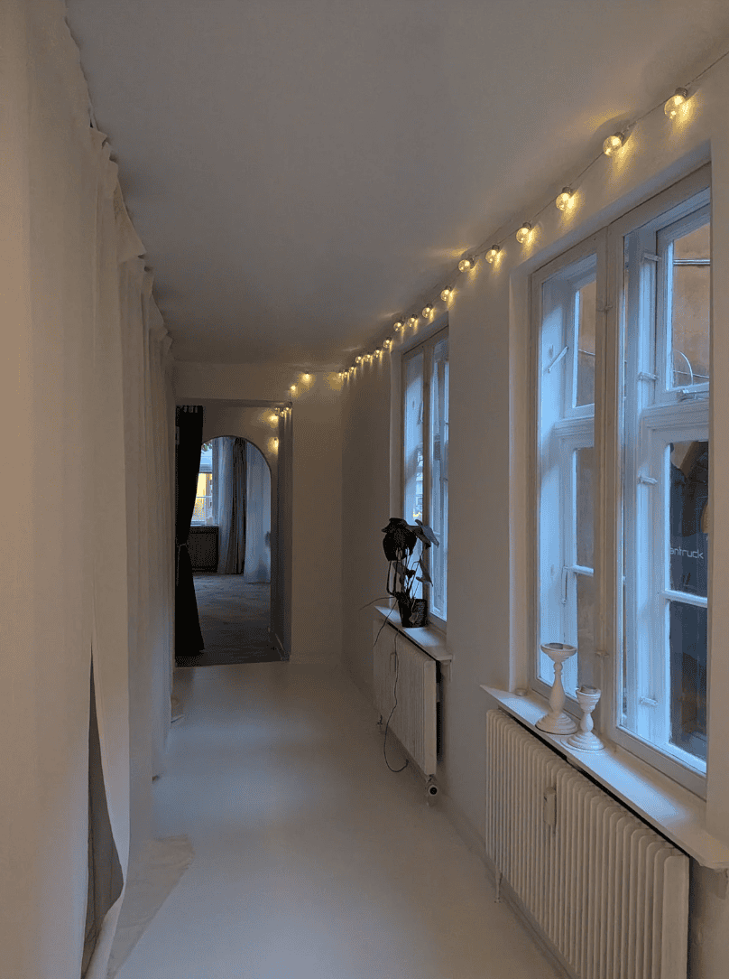 White hallway with light chain at the top and windows to the right